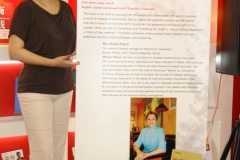 Tjanjin-_Mirjana-pored-plakata-koji-najavljuje-promociju-njene-knjige-scaled